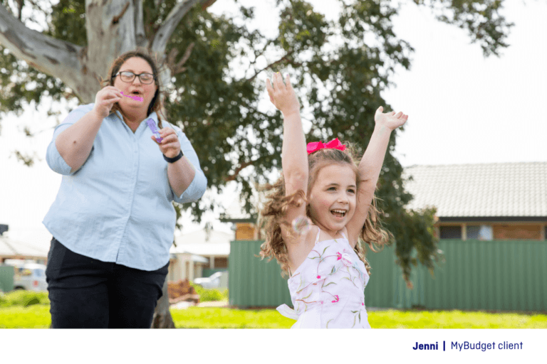 Australian single mum Jenni, a MyBudget client, blowing bubbles with her daughter after taking control of her finances.
