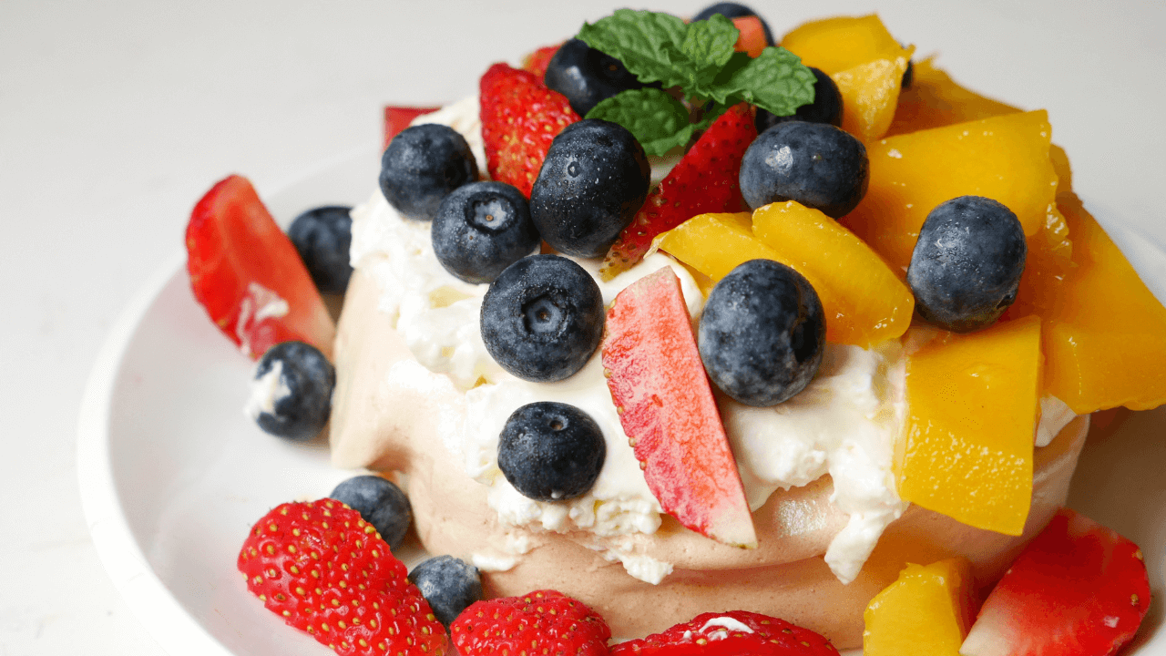 A vibrant pavlova topped with fresh fruits, showcasing how creative budgeting can deliver iconic Australian desserts for a festive feast without stretching your finances.