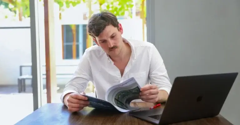 A man reviewing his finances at home, representing money stress and how MyBudget helps Australians reduce financial pressure.