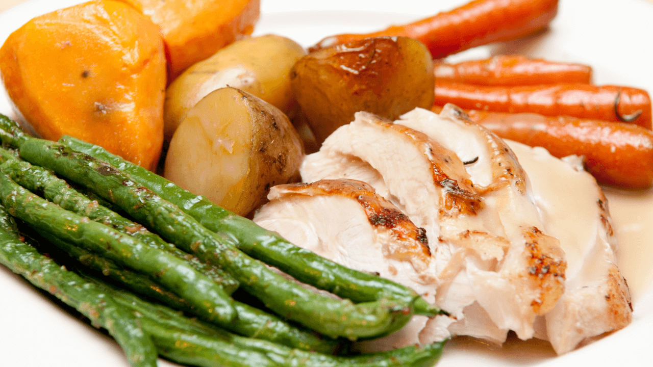 A hearty roast turkey with colourful vegetables, showcasing how thoughtful budgeting can help create memorable holiday meals without overspending, ensuring a festive season filled with delicious moments.