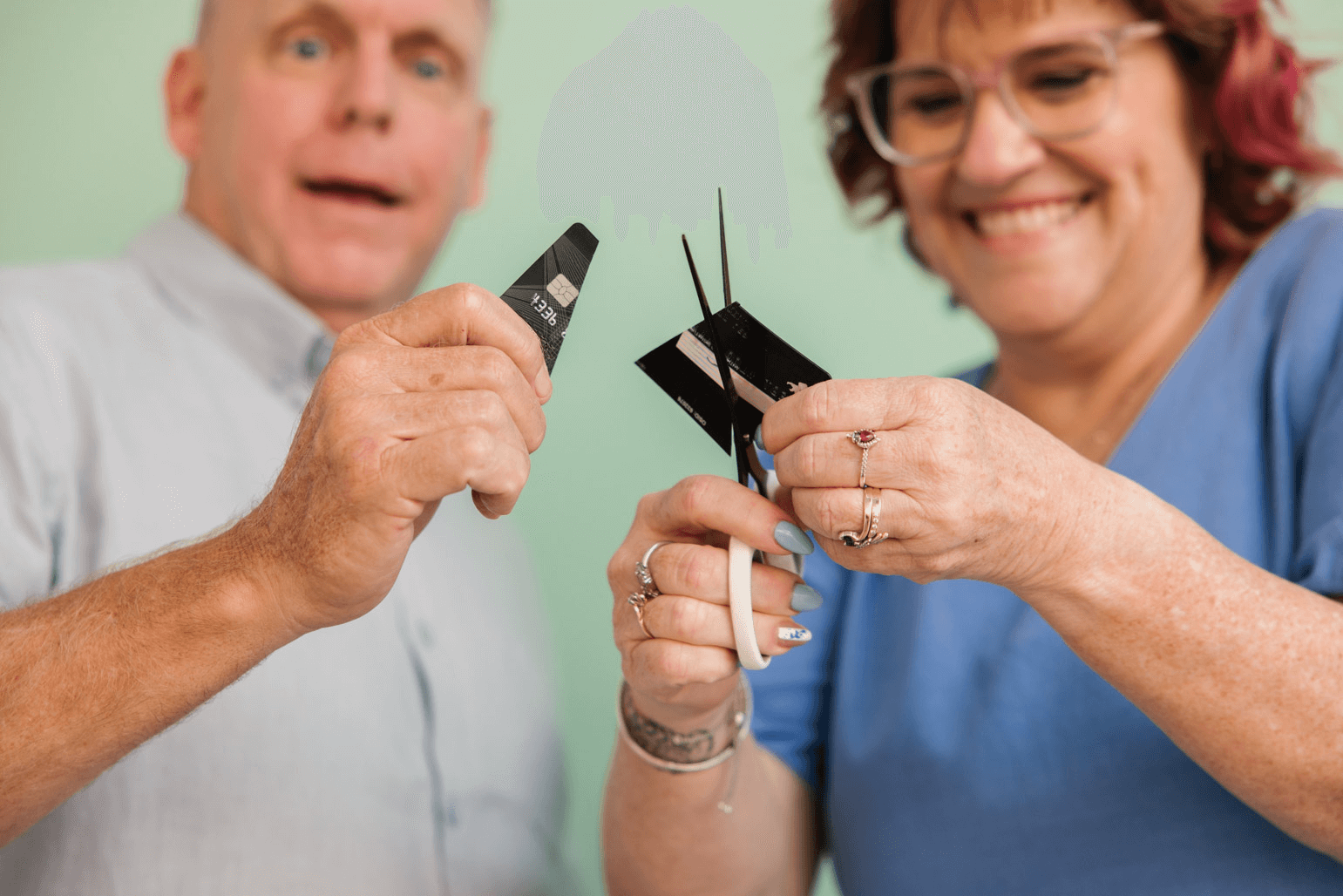 MyBudget clients Michelle and Phil cutting a credit card as a symbolic step towards debt freedom and better budgeting habits.