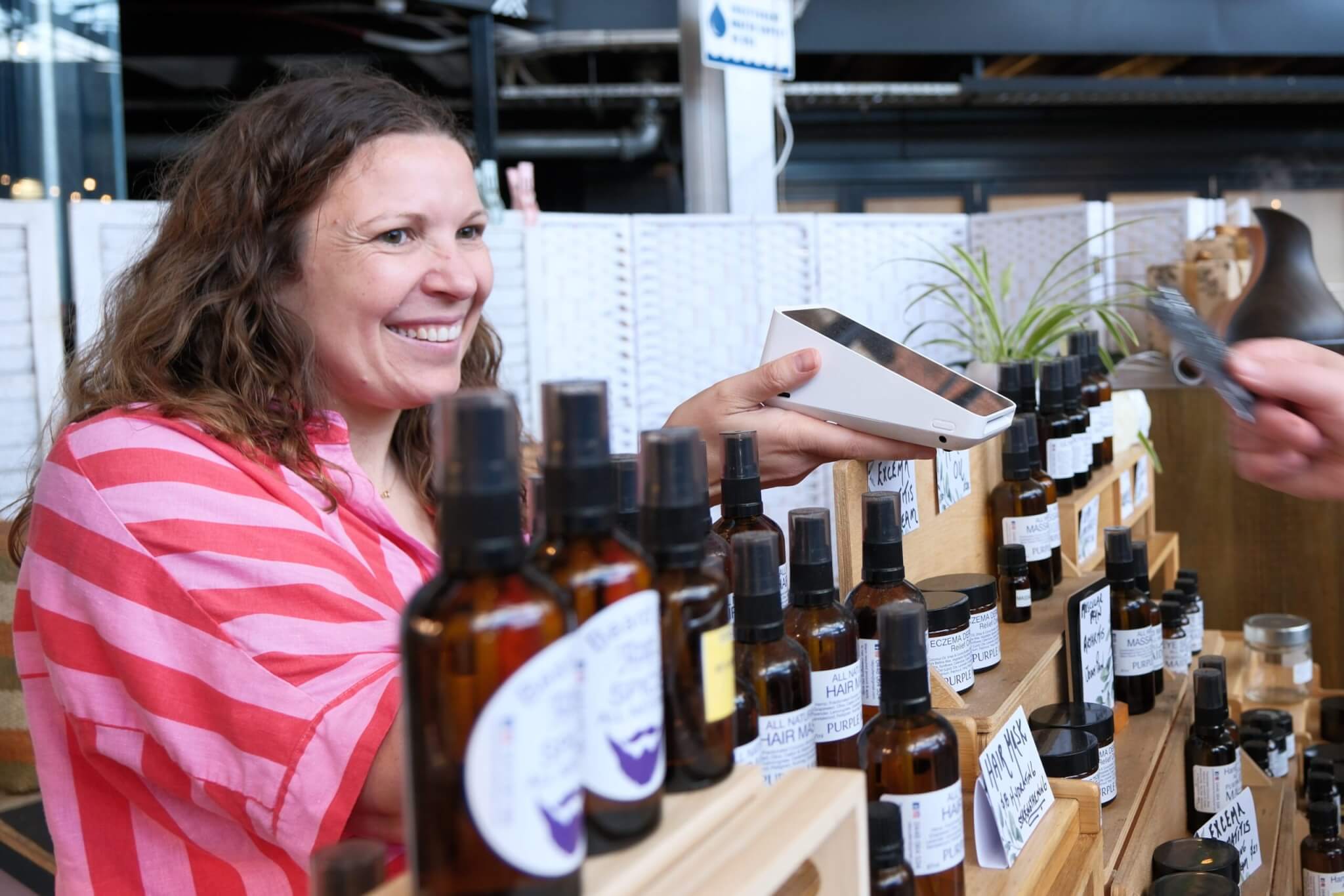 Small business owner showcasing handmade products at a vibrant market stall, capturing the essence of side hustles and entrepreneurial spirit.