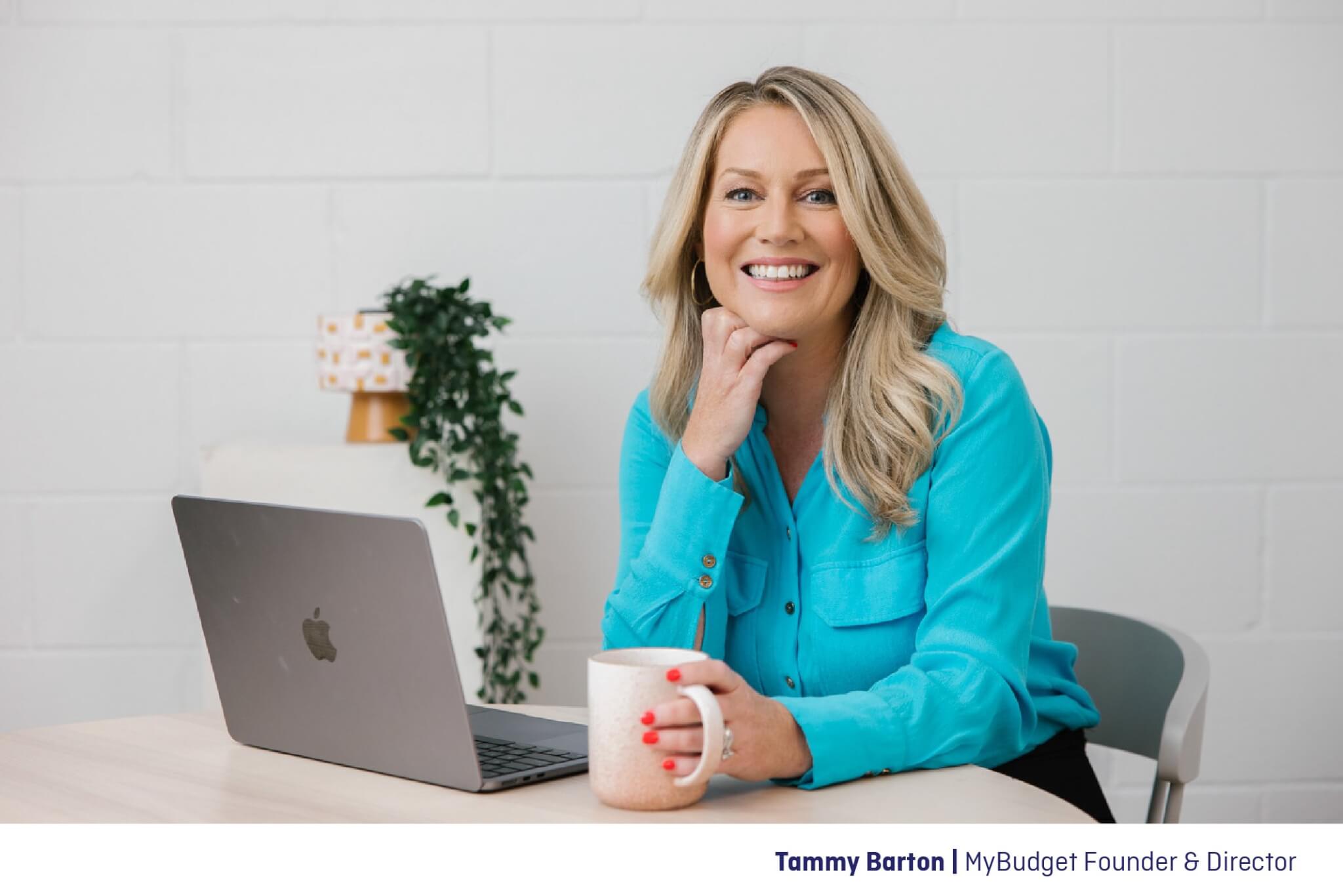 Tammy Barton, Founder of MyBudget, at her desk with a laptop and mug, sharing expert tips on saving money on household bills.
