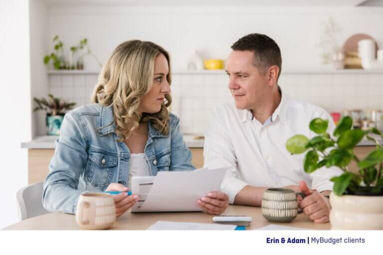 Erin and Adam, MyBudget clients having a coffee together at the kitchen table reviewing their budget