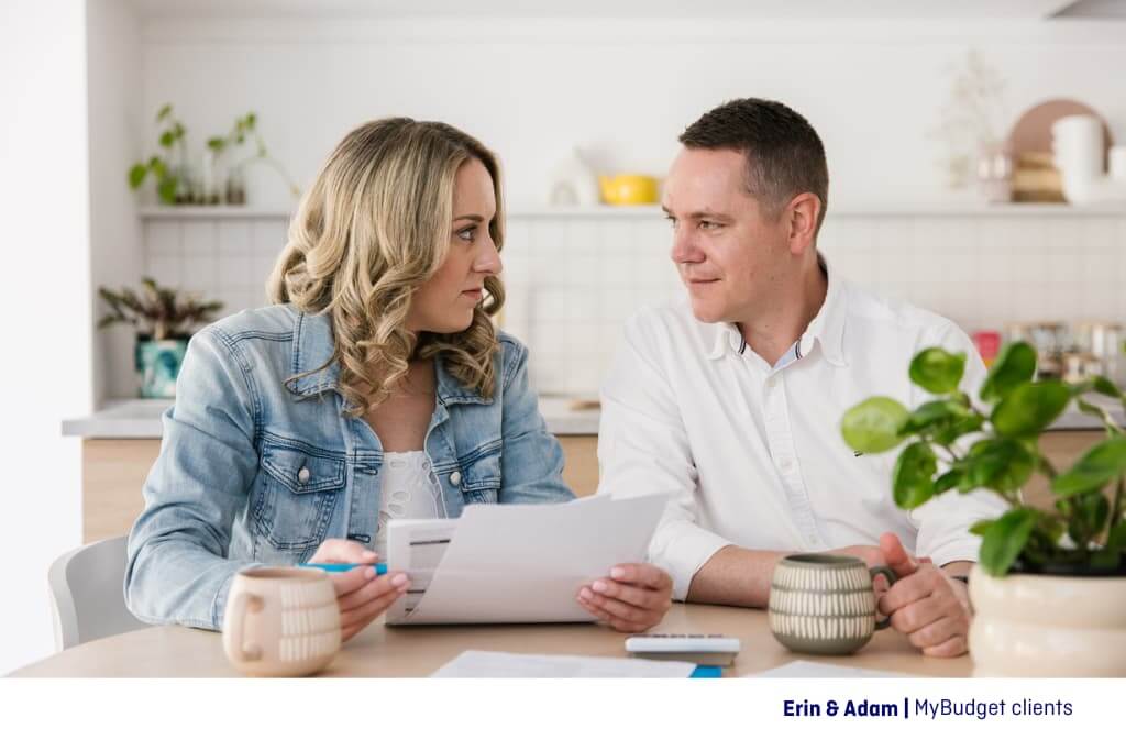 Erin and Adam, MyBudget clients having a coffee together at the kitchen table reviewing their paid subscriptions