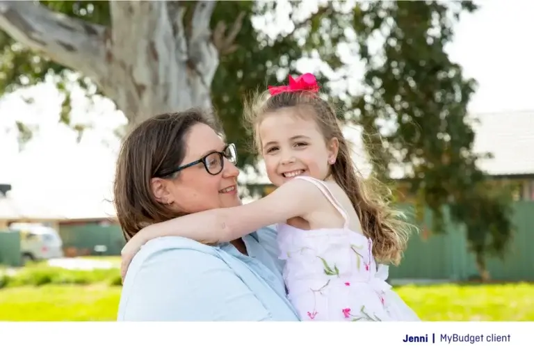 Jenni, a single parent and MyBudget client in Australia, hugging her daughter after creating a personal budget to manage school costs with confidence.