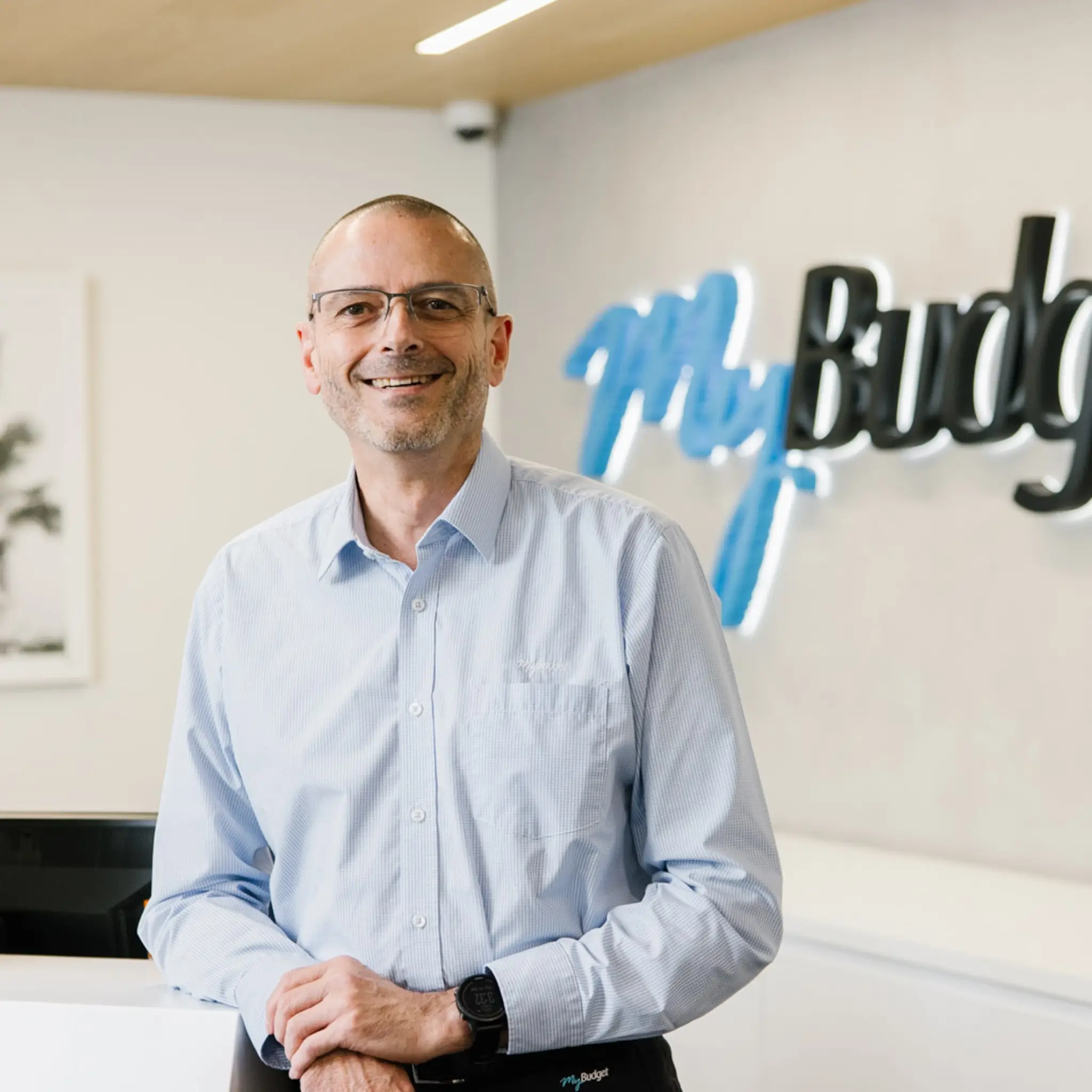 A smiling MyBudget team member at reception of the MyBudget offices in Australia.