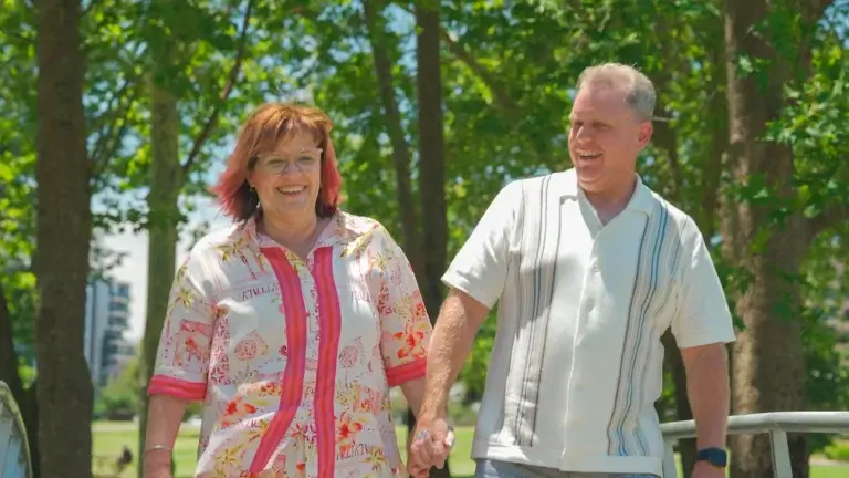 MyBudget clients Michelle and Phil smiling while walking together outdoors