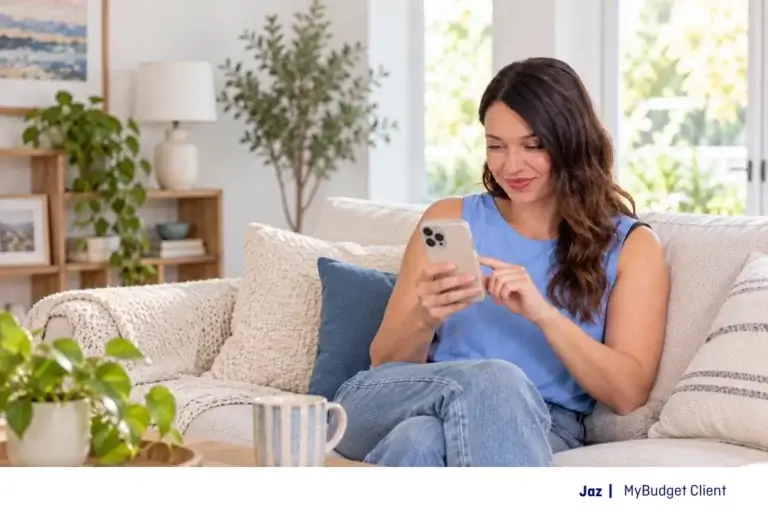 MyBudget client Jaz browsing online sales on her mobile phone while relaxing on the couch.