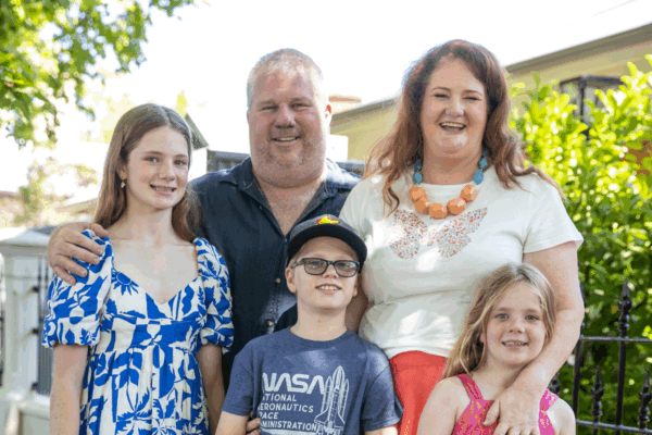 Alyssa and Pete, MyBudget clients, smiling with their three kids after achieving their goal of becoming a one income family.