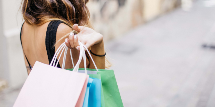 A young lady carrying multiple shopping bags over her right shoulder - can afterpay affect your credit rating?