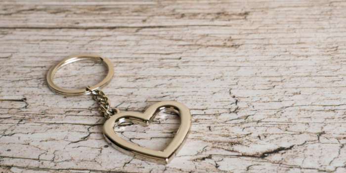 A gold hear keyring placed on a bench