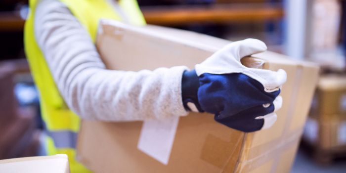 How to move on a budget - A person wearing gloves and a yellow hi-vis safety vest carrying a cardboard box.