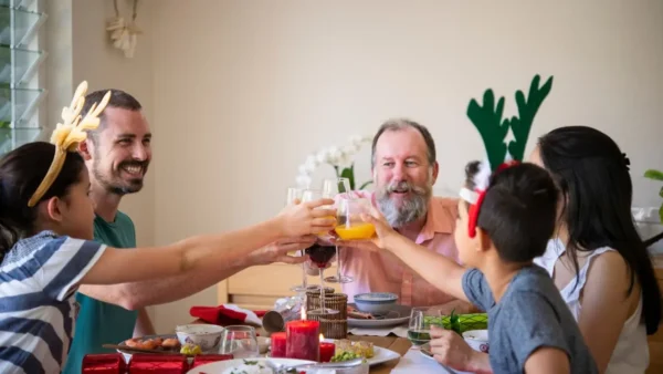 A family enjoying a festive Christmas lunch together, showing how thoughtful planning and budgeting can create the perfect celebration without overspending.