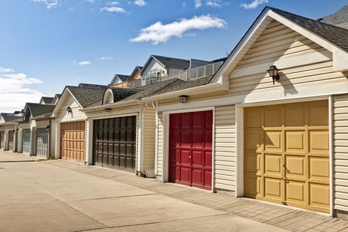 A row of homes with colourful garage doors.