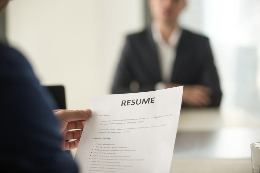 Close up photo of someone in a suit holding a printed resume