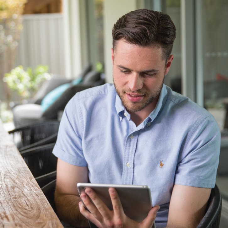 White man in his thirties looking at an ipad