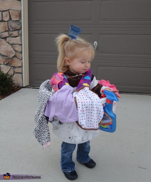 A young girl wearing a basket with dirty laundry as a low cost halloween costume