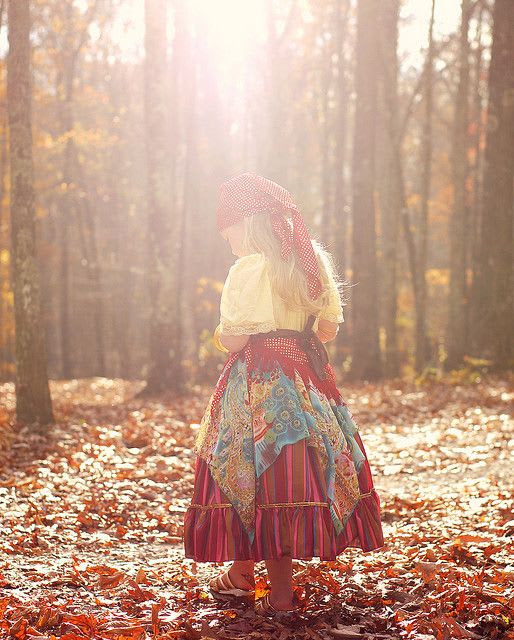 A young girl in a forest wearing a bandana, a simple shirt and a long skirt, dressed like a fortune-telling gypsy as a low cost halloween costume