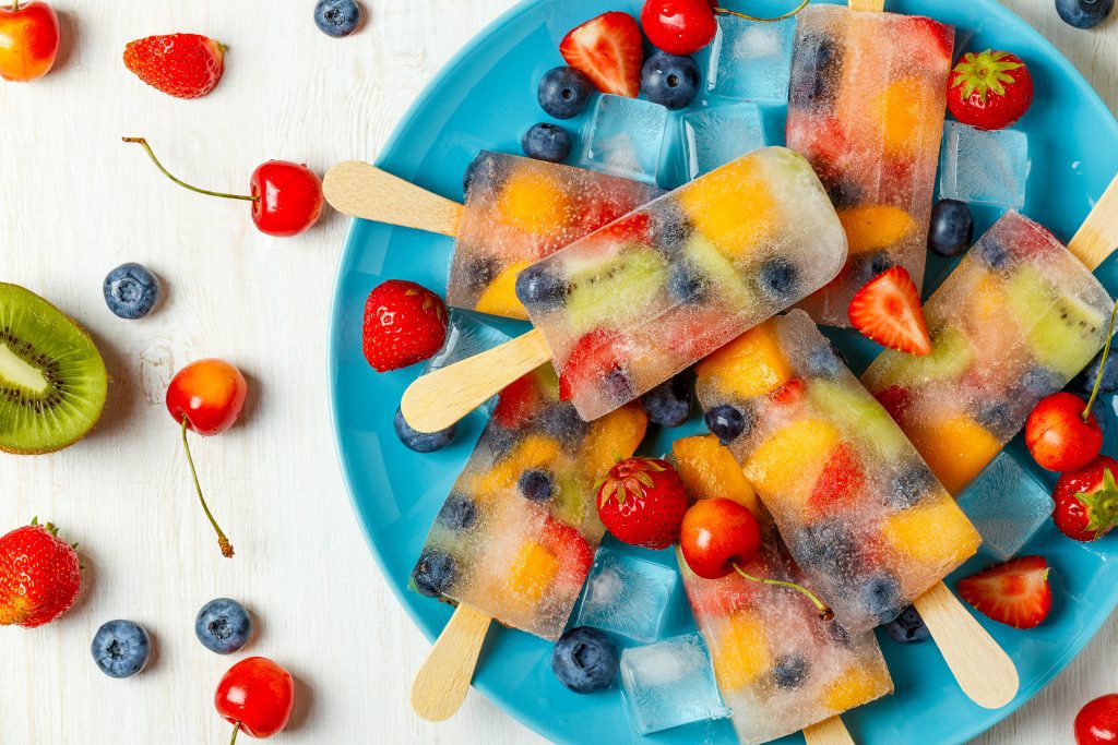Fruit ice blocks in a bowl with strawberries, cherries, blueberries and kiwifruit