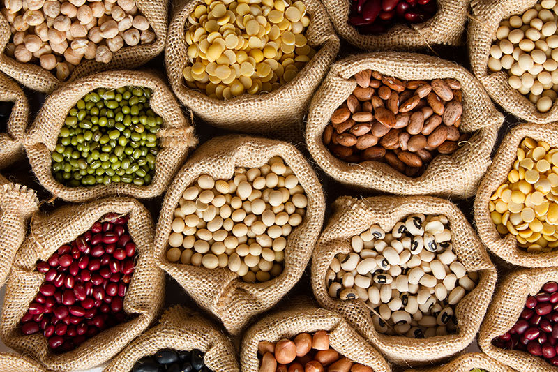 Harem mesh bags of grains and nuts including cannellini beans, macadamias, almonds, kidney beans, hazelnuts.