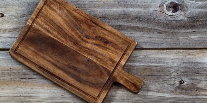 A wooden paddle board on a wooden table - Cheap Mother’s Day gifts