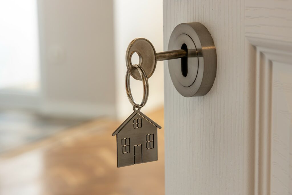 A key in a door with a house for a keyring attached - Australian Federal Budget 2022