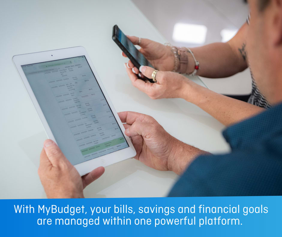 A person holds an iPad in front of them and a person sitting next to them holds a phone. Both are reading the screens. With text: With My Budget, your bills, savings and financial goals are managed within one powerful platform.