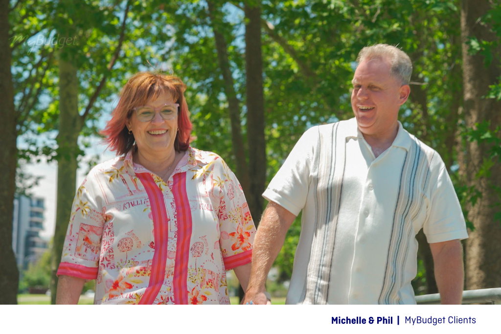 MyBudget clients Michelle and Phil walk hand in hand, feeling confident about their retirement plans after 11 years with MyBudget.