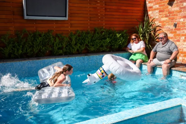 MyBudget clients Alyssa and Pete enjoying a fun-filled holiday by the pool with their family, symbolising how effective budgeting can make memorable family getaways possible.